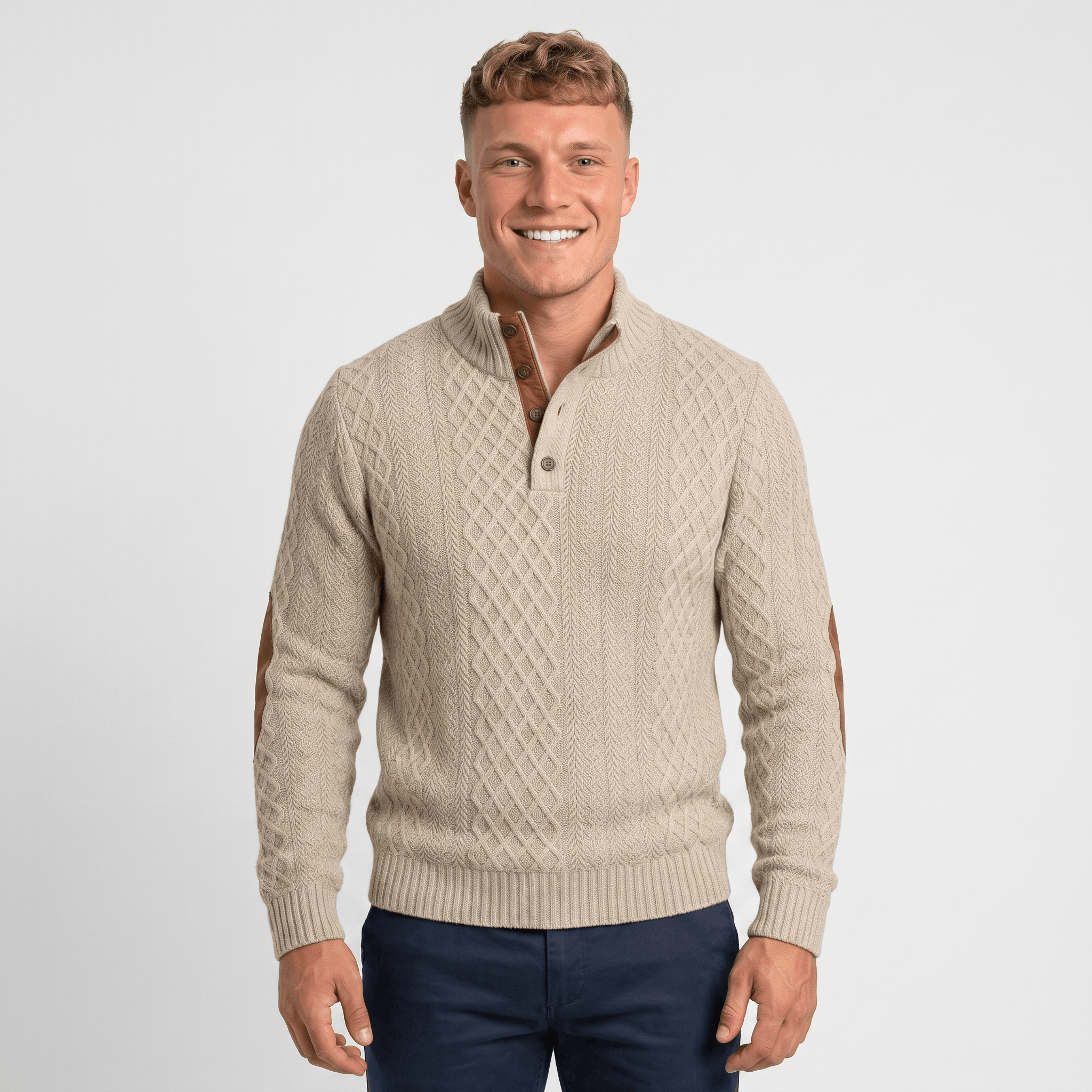 Man wearing a cream cable knit Henley sweater with a stand collar, button placket, faux suede elbow patches, and a classic fit.