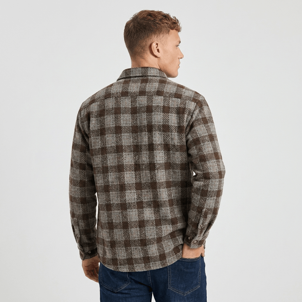 Back view of a man wearing a brown and gray plaid overshirt jacket with a relaxed fit and long sleeves.